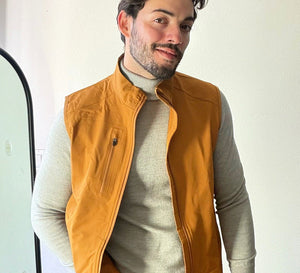 The model, wearing a Windproof Golf Vest, has one hand in her pocket and is looking directly at the camera.