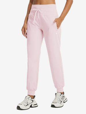 Model wearing women's stretch fleece lined water resistant joggers in light purple, showcasing the front lower body view.