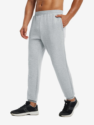 Front lower body view of model wearing soft sweatpants with 4 zipper pockets in light grey heather