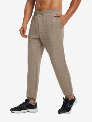 Front lower body view of model wearing soft sweatpants with 4 zipper pockets in light brown heather