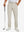 Lightweight moisture wicking dress pants in light khaki, front lower-body with model leaning on golf club.
