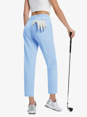 Back lower-body view holding a golf ball with glove in rear pocket wearing LIGHT BLUE Women's 7/8 Ankle Golf Track Pants.