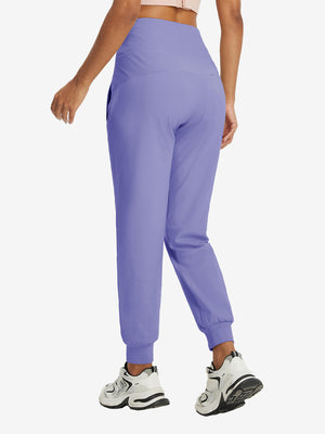 Model wearing women's stretch fleece lined water resistant joggers in lavender, showing the back lower body view.