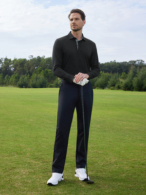 Model in black long sleeve solid jersey polo holding a golf club outdoors, full-body shot