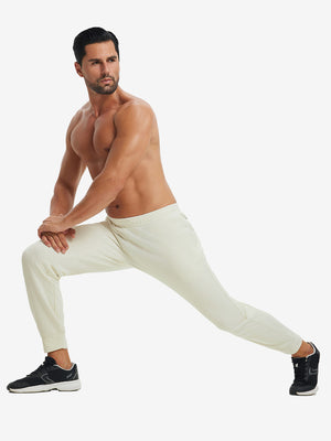 Model performing lunges in soft sweatpants with 4 zipper pockets beige