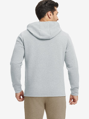 Back view of model wearing texture solid hoodies pullover showing fit and hood detail, light grey heather.