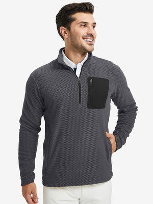 Model with one hand in side pocket, wearing midweight warm stretchy quarter zip pullover in grey.