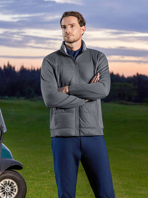 Model standing on course with hands clasped, golf fleece winter puffer jackets styled in dark grey