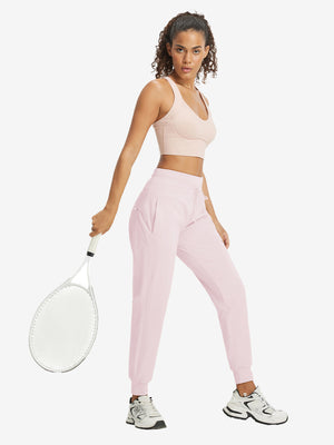 Full-body front view of model wearing women's stretch fleece lined water resistant joggers in light purple.