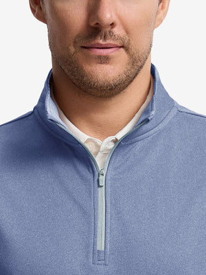 Front shot from nose to chest of model wearing navy melange lightweight sleeveless quarter zip golf vest