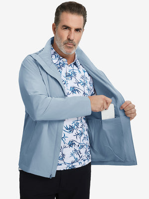 Model placing an iPhone into the inner pocket of the lightweight water-repellent softshell hooded jacket in slate blue.