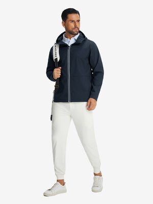 Model with backpack, wearing reflective hooded softshell jacket in navy, full-body outdoor look.