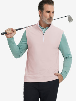 Model holding golf club, wearing print collar quarter zip golf vest in light pink, upper body view.