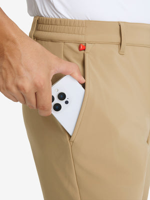 Close-up detail showing phone being placed in the pocket of khaki water-resistant stretch heat-tech winter trousers