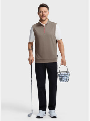 Front full body shot of model wearing brown melange  lightweight sleeveless quarter zip golf vest, holding a golf club in one hand and carrying a basket of golf balls in the other hand