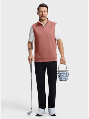 Front full body shot of model wearing brick melange  lightweight sleeveless quarter zip golf vest, holding a golf club in one hand and carrying a basket of golf balls in the other hand