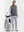 Front full body shot of model wearing black melange lightweight sleeveless quarter zip golf vest with one hand resting on golf bag