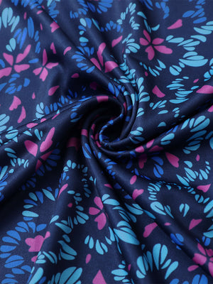 Close-up of navy colorful flower performance print boys golf polo fabric showing moisture-wicking texture and vibrant pattern.