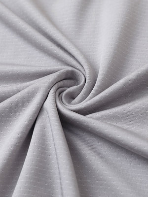Close-up of light grey 4 way stretch jacquard polo fabric texture highlighting intricate woven pattern and elasticity.
