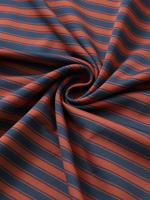 Close-up of rusty red navy yarn dyed stripe polo fabric showing distinct woven stripes and textured surface. 