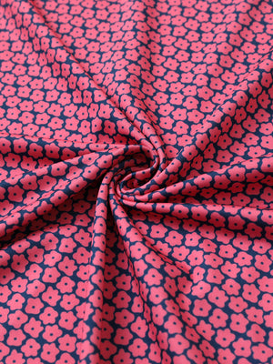 Close-up of rose flower performance jersey print polo fabric showing breathable texture and vibrant pattern details.