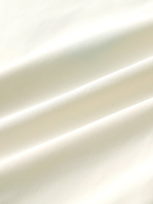 Close-up of beige water resistant everyday pants fabric showing durable texture and protective finish.