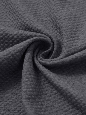 Close-up of fabric on textured insulated winter jacket, showing texture and finish in grey heather