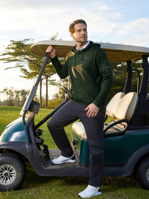 Model wearing dark green heather fleece hoodies pullover sitting on a golf cart at the course.