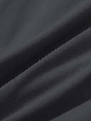 Close-up texture of dark grey stretch cotton blend slim fit golf trousers 5 pockets fabric showing detailed cotton blend weave.