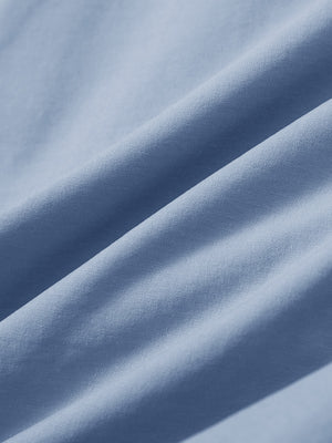 Close-up texture of sky blue stretch cotton blend slim fit golf trousers 5 pockets fabric showing detailed cotton blend weave.