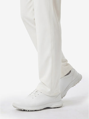 Detail view of hem and lower leg on white women's regular fit stretchy golf pants