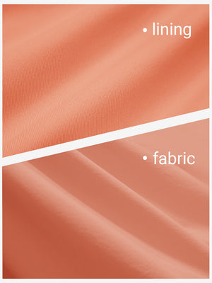 Close-up texture of peach pink women's gym golf shorts with liner pocket fabric showing detailed outer and inner lining material.