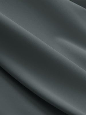 Close-up texture of dark gray breathable casual slacks with 4 pockets fabric showing detailed breathable material and weave.