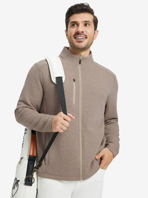 Full body shot, model carrying golf bag in textured insulated winter jacket, active outdoor style, light brown heather.