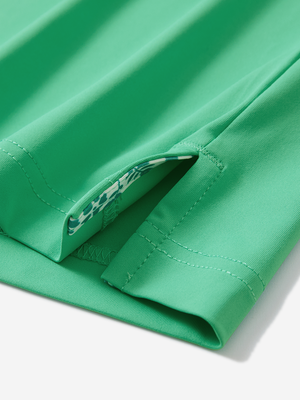 Detail of the side vent hem on the irland green everyday classic solid polo, showing the split hem feature